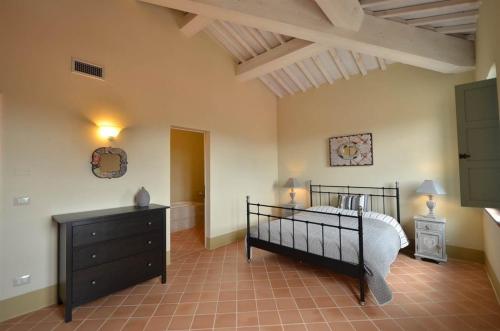 a bedroom with a bed and a dresser in a room at Appartamento Cipresso in Trequanda