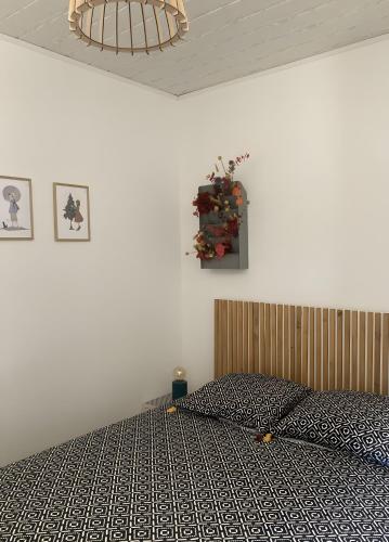 a bedroom with a bed with a black and white comforter at Petit nid pour oiseaux de passage in Cayriech