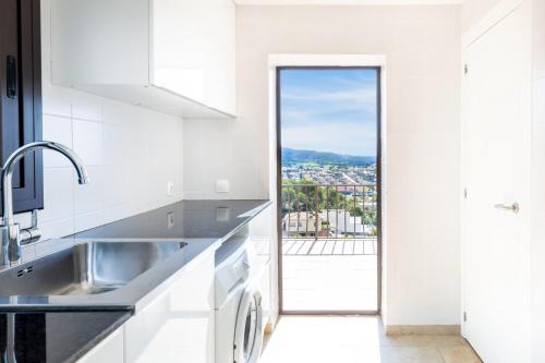 a kitchen with a sink and a view of a city at Casa Vista Del Mar in Calonge