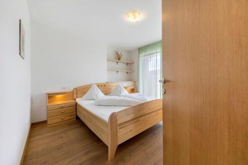 a bedroom with a bed and a wooden door at Obertrisaierhof Wohnung 4 in Fie allo Sciliar