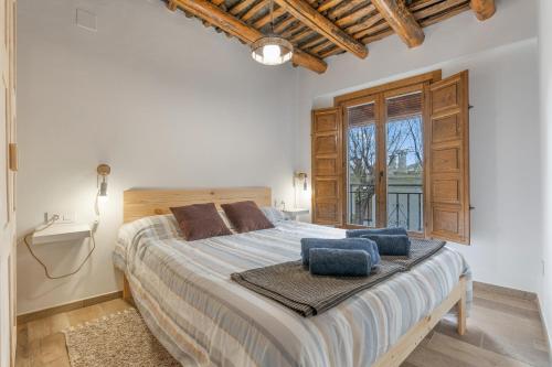 a bedroom with a large bed with blue pillows on it at Casa Pepa in Pampaneira