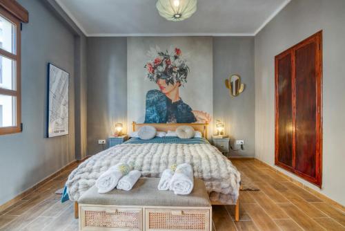 a bedroom with a large bed with a painting on the wall at La Bonita de Pego in Pego