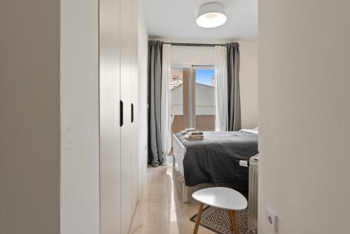 a bedroom with a bed and a table and a stool at Casa Sunshine in Marbella