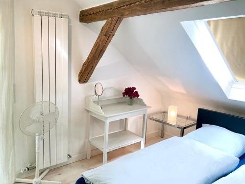 a bedroom with a white bed and a table with flowers at Haus Haselmaus - Buntspecht in Schwäbisch Gmünd