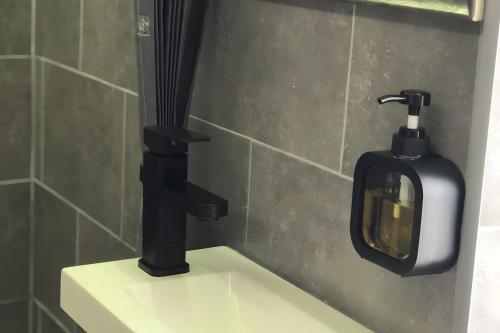 a soap dispenser on top of a toilet in a bathroom at Charming House Secret Rose in Flor da Rosa