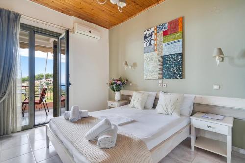 a bedroom with a bed and a balcony at Nontas Home 33 in Kalamitsi
