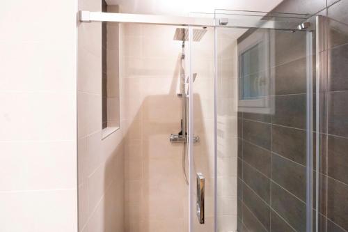 a shower with a glass door in a bathroom at Maison Cosy avec Piscine in Tarnos