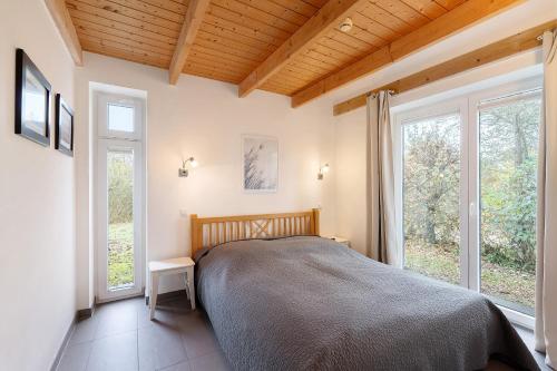 ein Schlafzimmer mit einem Bett und zwei Fenstern in der Unterkunft Badeuferhaus in Kosel