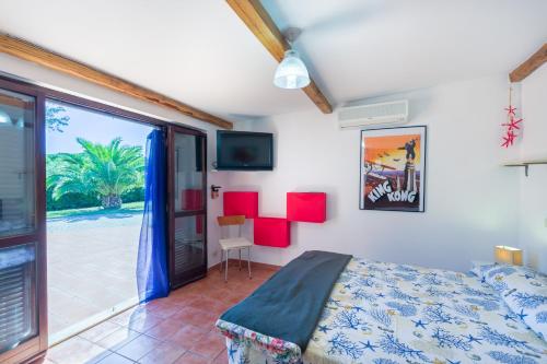 a bedroom with a bed and a sliding glass door at Villa Roberta Marina di Campo in Marina di Campo