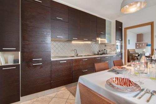 a kitchen with wooden cabinets and a table with a plate of food at Como Lake Home in Colico
