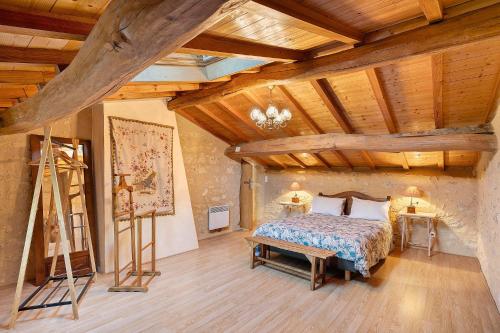 a bedroom with a bed and a wooden ceiling at Gite La Roseraie in Saint-Émilion