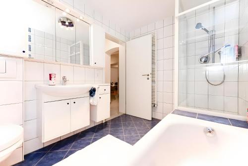 a white bathroom with a tub and a sink at Ferienwohnung Sieglinde in Bad Dürrheim