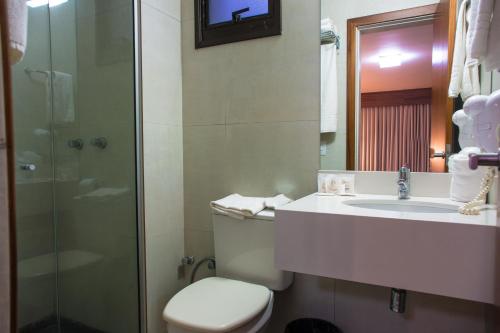 a bathroom with a toilet and a sink and a shower at Hotel Continental Business - 200 metros do Complexo Hospitalar Santa Casa in Porto Alegre