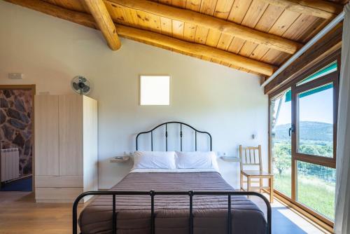 a bedroom with a bed and a large window at Casa Tunino in Monforte de Lemos