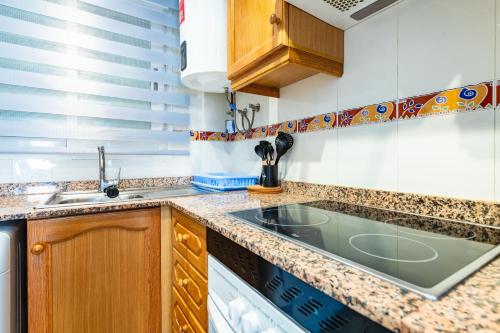 a kitchen with a sink and a stove at Quintana's Home Oropesa Del Mar in El Borseral