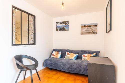 a living room with a couch and a chair at Maison traditionnelle au centre in Les Sables-d'Olonne