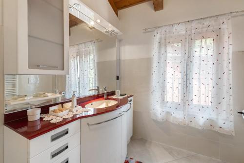 a bathroom with a sink and a mirror at Maison Nature e Relax Rubino in Osiglia