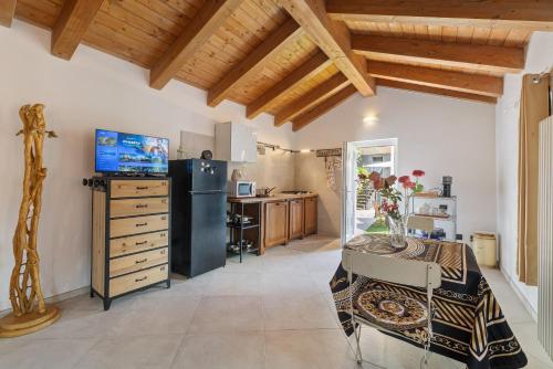 a kitchen with a table and a black refrigerator at Maison Nature e Relax Rubino in Osiglia