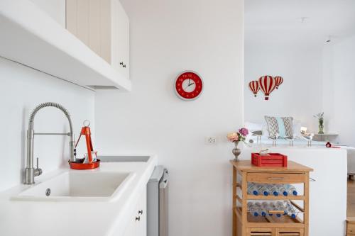 a white kitchen with a sink and a refrigerator at Luna Rossa Milos - Cocoon in Provatas