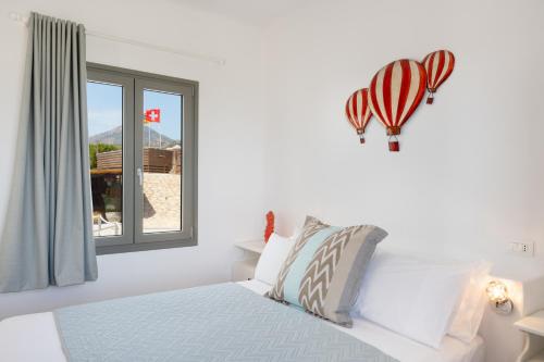 a white bedroom with a bed and a window at Luna Rossa Milos - Cocoon in Provatas