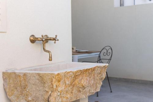 a bathroom with a stone sink with a faucet at Matinè Suite And Room in Matino