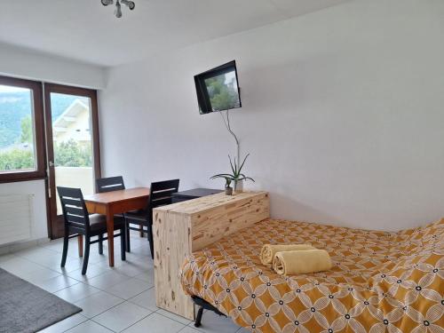 a bedroom with a bed and a desk and a table at Au calme avec balcon proche Genève in Gaillard