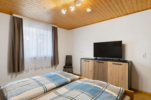 a bedroom with a bed and a flat screen tv at Apartments Winder 3 in Lustenau