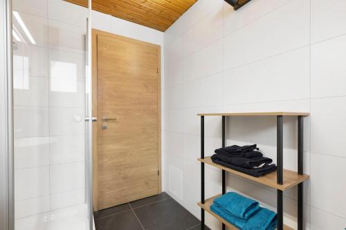 a bathroom with a shower and a wooden door at Apartments Winder 3 in Lustenau