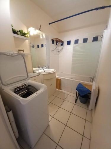 a bathroom with a toilet and a sink and a tub at Côte fleurie -Le Cottage D'honfleur in Honfleur