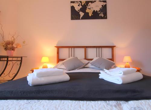 a large bed with white pillows and a map on the wall at Côte fleurie -Le Cottage D'honfleur in Honfleur