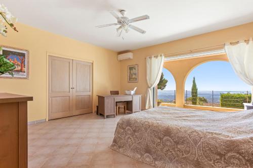 a bedroom with a bed and a desk and a window at La Cabri 5 Chambres Piscine in Cabris
