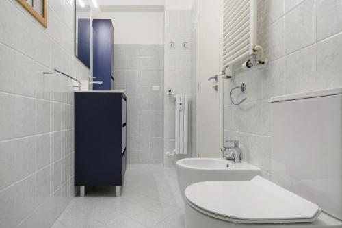 a white bathroom with a toilet and a sink at Portofino Garden in Rapallo