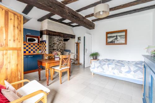 a bedroom with a bed and a table in a room at Charmante Longère La Meslière in Pannecé