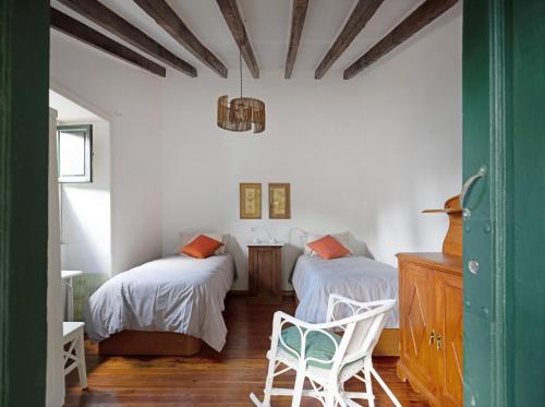 a bedroom with two beds and a chair at Casa Julia in Las Lagunas