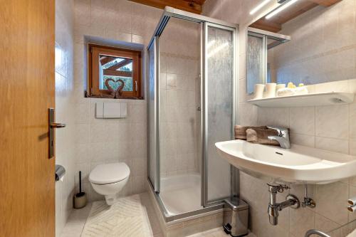 a bathroom with a shower and a sink and a toilet at Eichernhof Apartment Kirschblüte in Verano