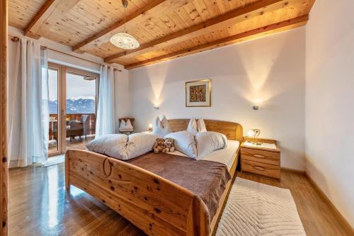 a bedroom with a large bed and a large window at Eichernhof Apartment Kirschblüte in Verano