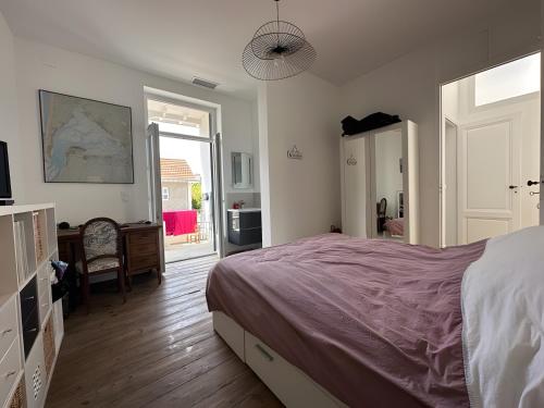 a bedroom with a bed and a room with a door at Appartement bord de plage-Arcachon in Arcachon