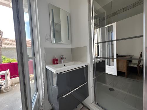 a bathroom with a sink and a mirror at Appartement bord de plage-Arcachon in Arcachon