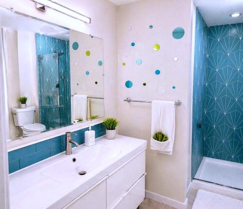 a bathroom with a sink and a mirror and a shower at CasaViva Breeze - 2BR with Sunset Views, Firepit & Backyard - Walk to Fun & Eats in North Park & Hillcrest, 5 Min to Gaslamp in San Diego