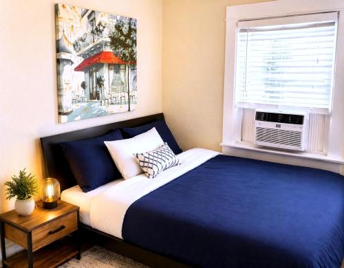 a bedroom with a blue and white bed and a window at CasaViva Breeze - 2BR with Sunset Views, Firepit & Backyard - Walk to Fun & Eats in North Park & Hillcrest, 5 Min to Gaslamp in San Diego