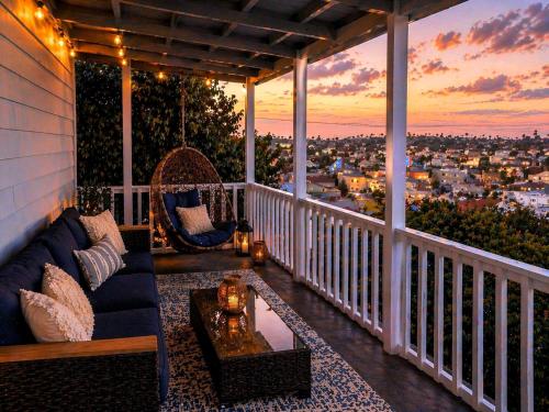 a porch with a couch and a view of the city at CasaViva Breeze - 2BR with Sunset Views, Firepit & Backyard - Walk to Fun & Eats in North Park & Hillcrest, 5 Min to Gaslamp in San Diego