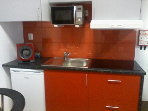 cocina con fregadero y microondas en Metro-Apartment RNAL nº35375 AL-Chamada para a rede móvel nacional, en Oporto