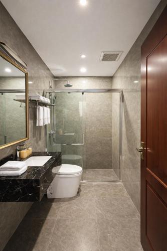 a bathroom with a shower and a toilet and a sink at Eden De Vangvieng in Vang Vieng