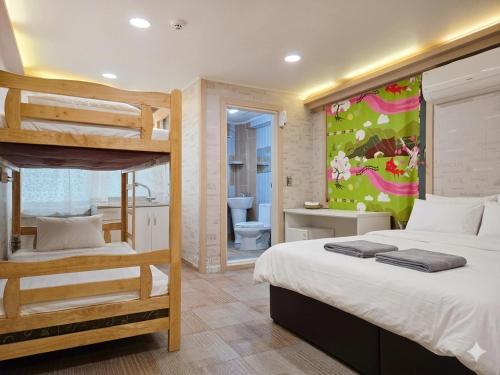a bedroom with two bunk beds and a bathroom at Family Hotel BNB in Busan