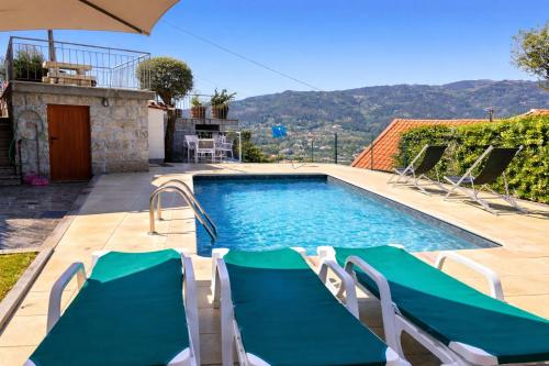a swimming pool with lounge chairs next to a house at Casa da Lage - Piscina privada - Vistas rio - "Gerês" in Geres