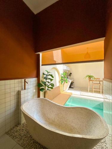 a bath tub in a bathroom with a swimming pool at At Paviliun With Private Pool in Timuran