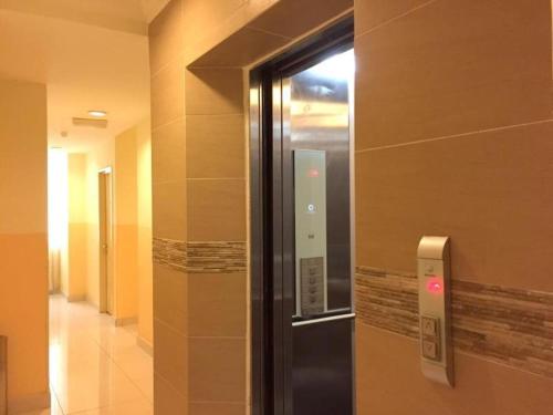 a glass door in a hallway with a elevator at Sun Inns Setiawan in Sitiawan