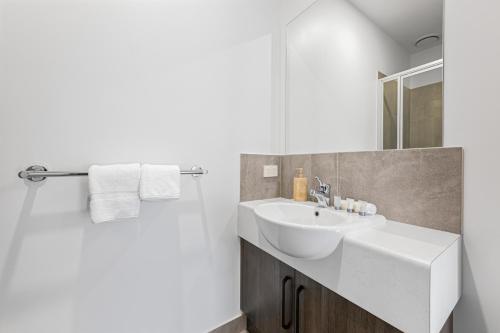a white bathroom with a sink and a mirror at Rivergardens Holiday Park Mildura in Gol Gol