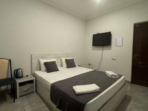 a bedroom with a bed with a television on the wall at Menua by Horizon Hotels, Yerevan in Yerevan