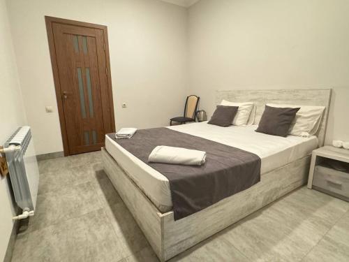 a bedroom with a large bed and a wooden door at Menua by Horizon Hotels, Yerevan in Yerevan